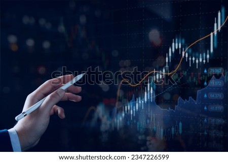 Stock market or forex trading graph and candlestick chart suitable for financial investment concept. Businessman analyzing economy trends background for business idea and all art work design. Royalty-Free Stock Photo #2347226599