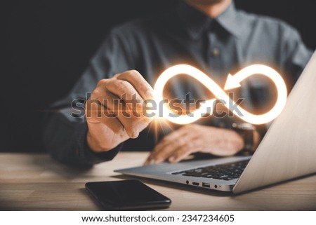 Businessman pointing at infinity symbol, symbolizing unlimited connection in data technology. Cyber space, future unlimited. Infinite power, energy, internet information. technology infinity data