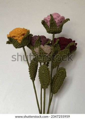 a bouquet of colorful knitted roses with a white background