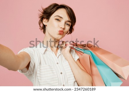 Close up young woman wear casual clothes hold shopping paper package bags doing selfie shot pov on mobile cell phone isolated on plain pink color background studio. Black Friday sale buy day concept