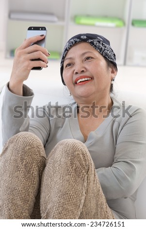 Smiling senior asian thai  woman using cell phone