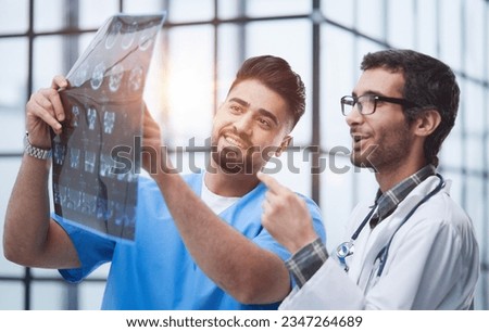 Two caucasian doctors view mri picture and discussing about it. Close up.
