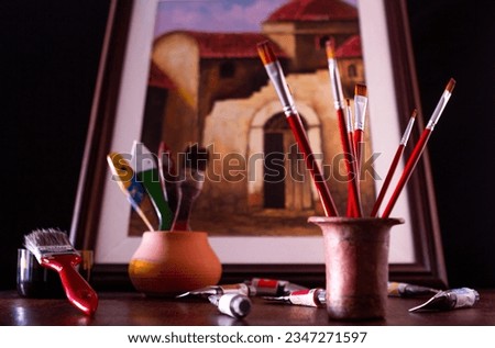 Painted picture and Artist's tools on a wooden table