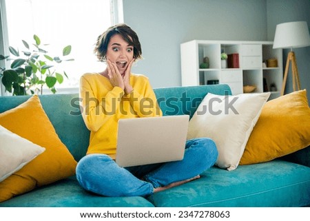 Photo of funny shocked lady browsing netbook impressed incredible shopping sale on website in modern apartments