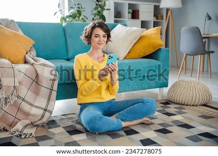 Photo of lovely pretty peaceful positive gorl use phone communicate friend sitting carpet loft interior flat indoor