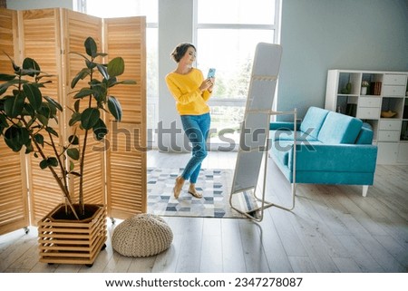 Photo of lovely cheerful cute girl shooting photographing news outfit looking mirror indoor house room