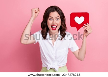 Photo of cute lucky lady wear white blouse rising fist heart feedback card isolated pink color background