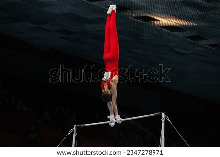 gymnast exercise horizontal bar in championship gymnastics, element handstand