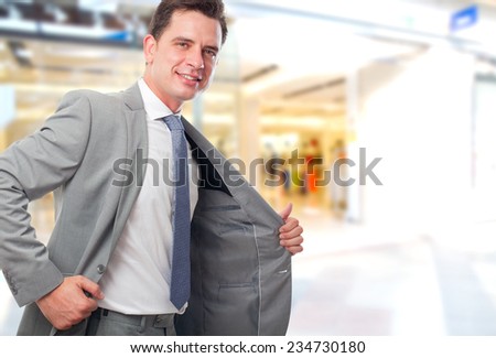 Business man over shopping center background. Looking happy