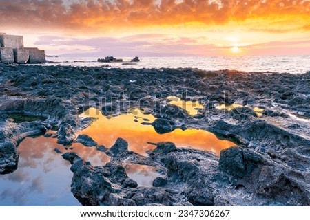 beautiful golden sunset or sunrise on a seashore bank with blue sea water and yellow sunnny evening cloudy sky and amazing reflection on water surface, ocean vacation landscape