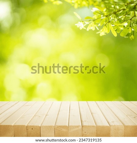 selective focus.real wood table top texture on blur leaf tree garden background.For create product display or design key visual layout