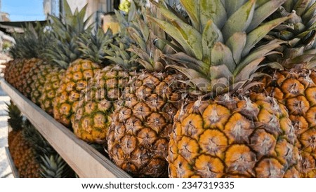 A row of pineapples on a stand Royalty-Free Stock Photo #2347319335