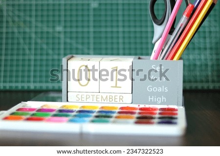 September 1. Image of september 1 wooden calendar on desktop. Autumn day. Back to school. Pencils and paints, stationery