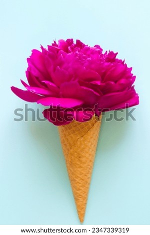 flower in waffle ice cone.Peony bouquet ice cream on blue background.Floral greeting card for Mothers day, birthday.Tender cover design and accessories print.