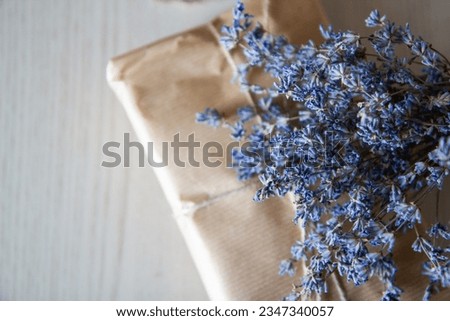 a gift in craft paper with a bouquet of lavender on the table