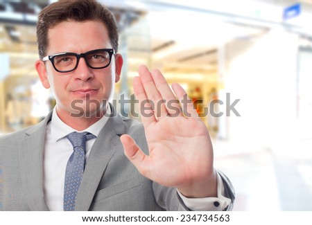 Business man over shopping center background. Showing his palm
