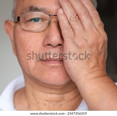 A man testing the vision on his right eye wearing a pair of varifocal glasses. Royalty-Free Stock Photo #2347356319