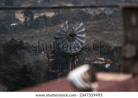 windmill with some broken blades with mountains in the background, Cordoba, Argentina
