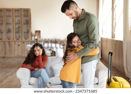 Divorce, Family Separation. Unhappy Kid Girl Hugging Dad While He Leaving Home With Suitcase After Quarrel, Child Suffering From Parents Breakup, Experiencing Problem In Marriage Relationship Royalty-Free Stock Photo #2347371685