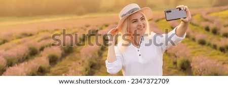 woman taking photo with mobile cell phone in the lavender field