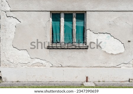 weathered stucco wall, old facade,  grungy abandoned facade of a ruined building. Vintage and lost place background with smashed broken roughcast, plaster and finery. Textured surface lit by sunlight. Royalty-Free Stock Photo #2347390659