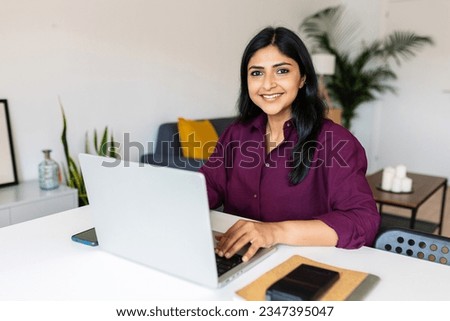 Portrait of cheerful indian business woman smile at camera using laptop at home. Entrepreneur and freelancer people concept. Royalty-Free Stock Photo #2347395047