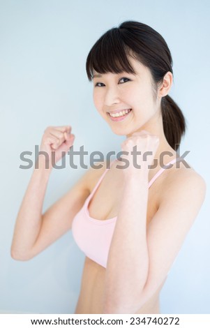 young fitness woman against pale blue background