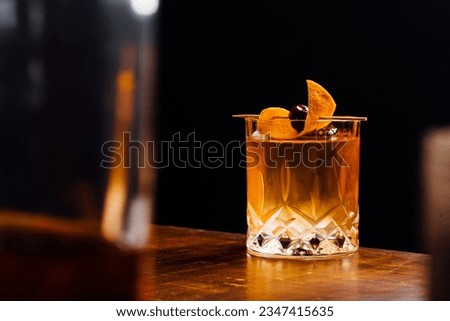 Alcoholic Old Fashioned Cocktail classic on the rocks garnish with orange peel and a cherry Royalty-Free Stock Photo #2347415635