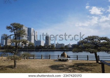 Hamarikyu Gardens, Chūō ward, Tokyo. A couple look out at the skyline of Tokyo Bay