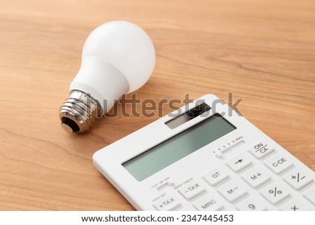 LED bulb and calculator on the table Royalty-Free Stock Photo #2347445453