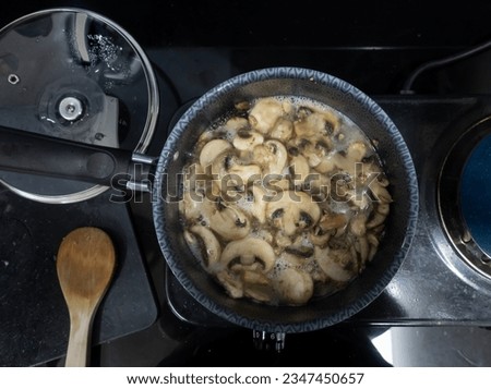 drop shot picture of an aluminum skillet cooking mushrooms