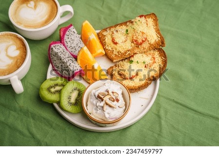 Breakfast toast with cheese and tomatoes, fruit, yogurt, coffee.