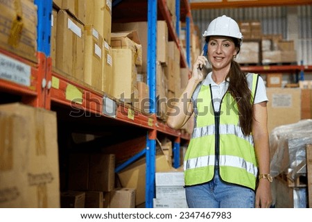 factory worker talking on smartphone to customer in warehouse factory