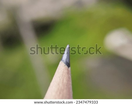 Colourful pencil with blurry green background 