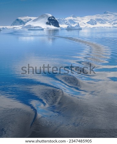 Back-lit berg; Antarctica; Zodiac wake ripples; Antarctic