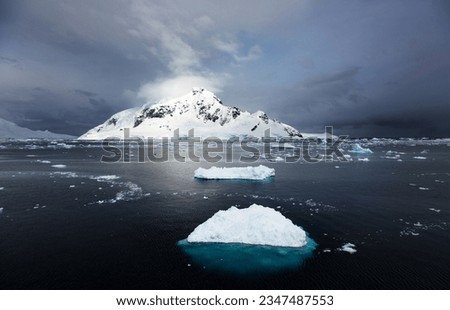 Berg before glowing mountain; Antarctic Peninsula; Berg under clearing clouds; Antarctic Peninsula; Cerulean ice floe at sunset; Antarctica