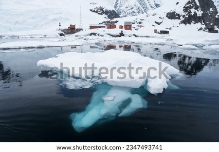 Mountainous cloudscape; Antarctica; Pink light on clouds; Scooped blue iceberg; Sculpted berg and brash ice; Sculpted berg reflection; Small berg with blue underwater tongue; Small iceberg with cloud