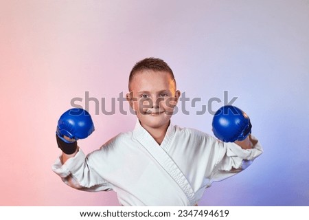 On a gradient colored background, a small sportsman in karategi Royalty-Free Stock Photo #2347494619