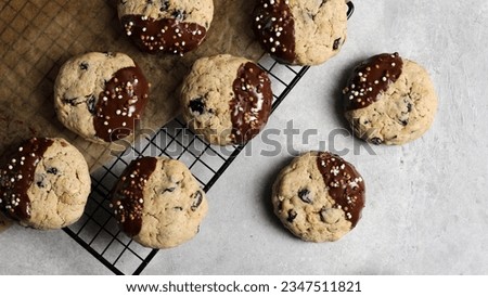 Close-up of oat cookies with raisins, dipped in chocolate and adorned with crispy bits, presented on a delicate background Royalty-Free Stock Photo #2347511821