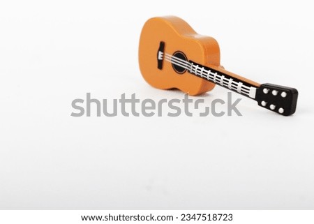 Plastic mini guitar toy isolated on white background