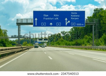 Blue freeway sign over the road in Germany on sunny day
