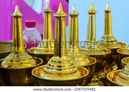 Golden water bottle for poring water for pray to dead people in Thailand culture.