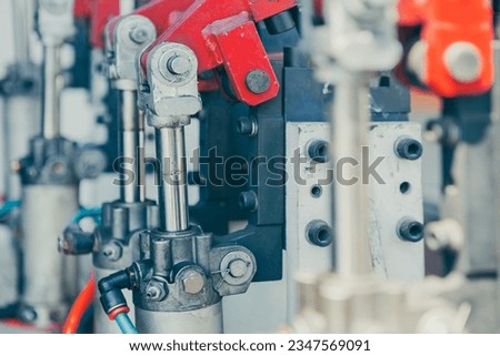 Close-up view of an industrial machine with red and gray metal parts including many hydraulic arms.
A mechanical device with hydraulic components. Royalty-Free Stock Photo #2347569091