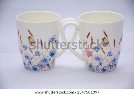 Mock up- design set of elegant and traditional teapot colorful butterfly  and blue flowers on white coffee cup and Tea cup on cup's plate beside the hot tea pot , design drink-ware isolated.