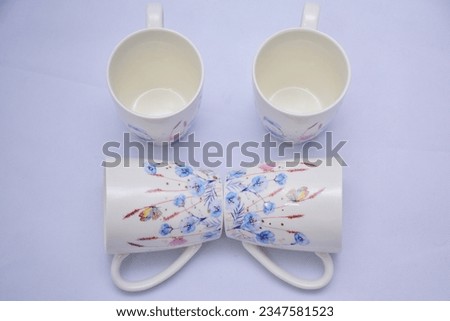 Mock up- design set of elegant and traditional teapot colorful butterfly  and blue flowers on white ceramic coffee cup and Tea cup on cup's plate beside the hot tea pot , design drink-ware isolated.