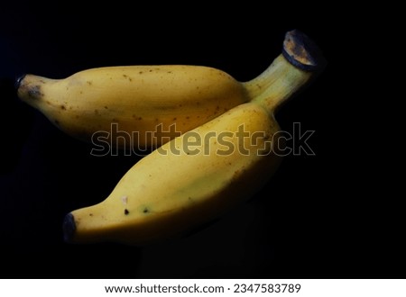 two bananas on a black background