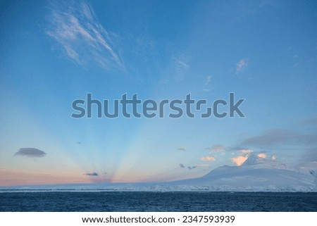 Antarctic cloudscape, near Island, Cuiverville, Blue Island; Anti-crepuscular rays, over Antarctic mountains