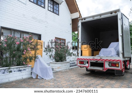 Background of cargo truck stop near house with many cardboard boxes and furniture waiting to move goods to new house, professional services logistic business moving house industry company concept