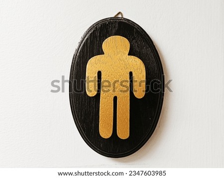 Men's toilet symbol, gold on a black background.