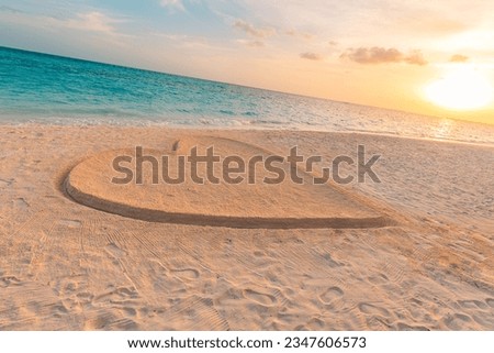 Heart on beach. Romantic composition, sunset coast view. Love symbol, abstract outdoors drawing in sandy island beach. Valentines, Love Romance couple togetherness landscape. Happy good loving feeling